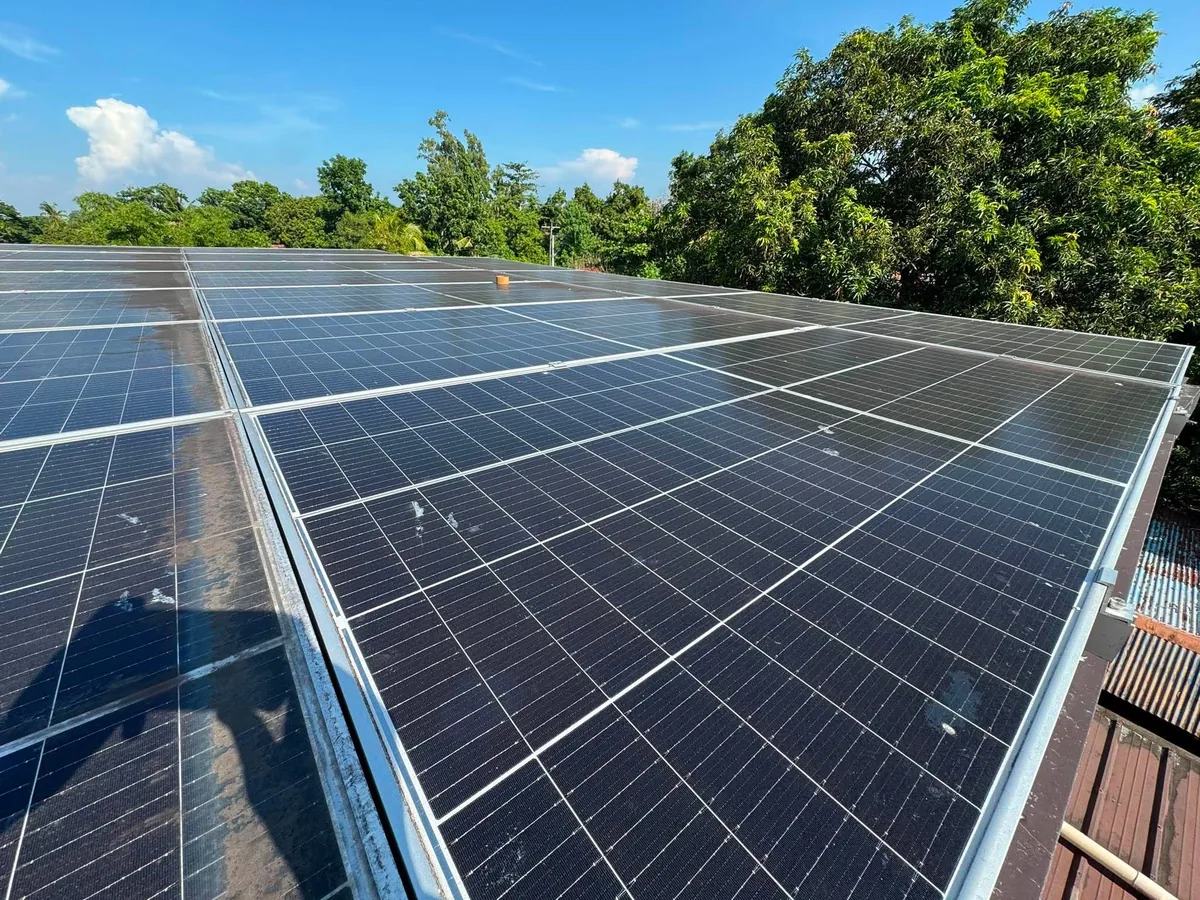 A dust-filmed rooftop solar array with visible grime and bird droppings on the glass.